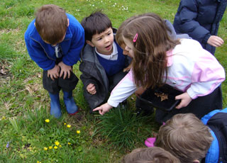Children in the garden talking and discussing their ideas.